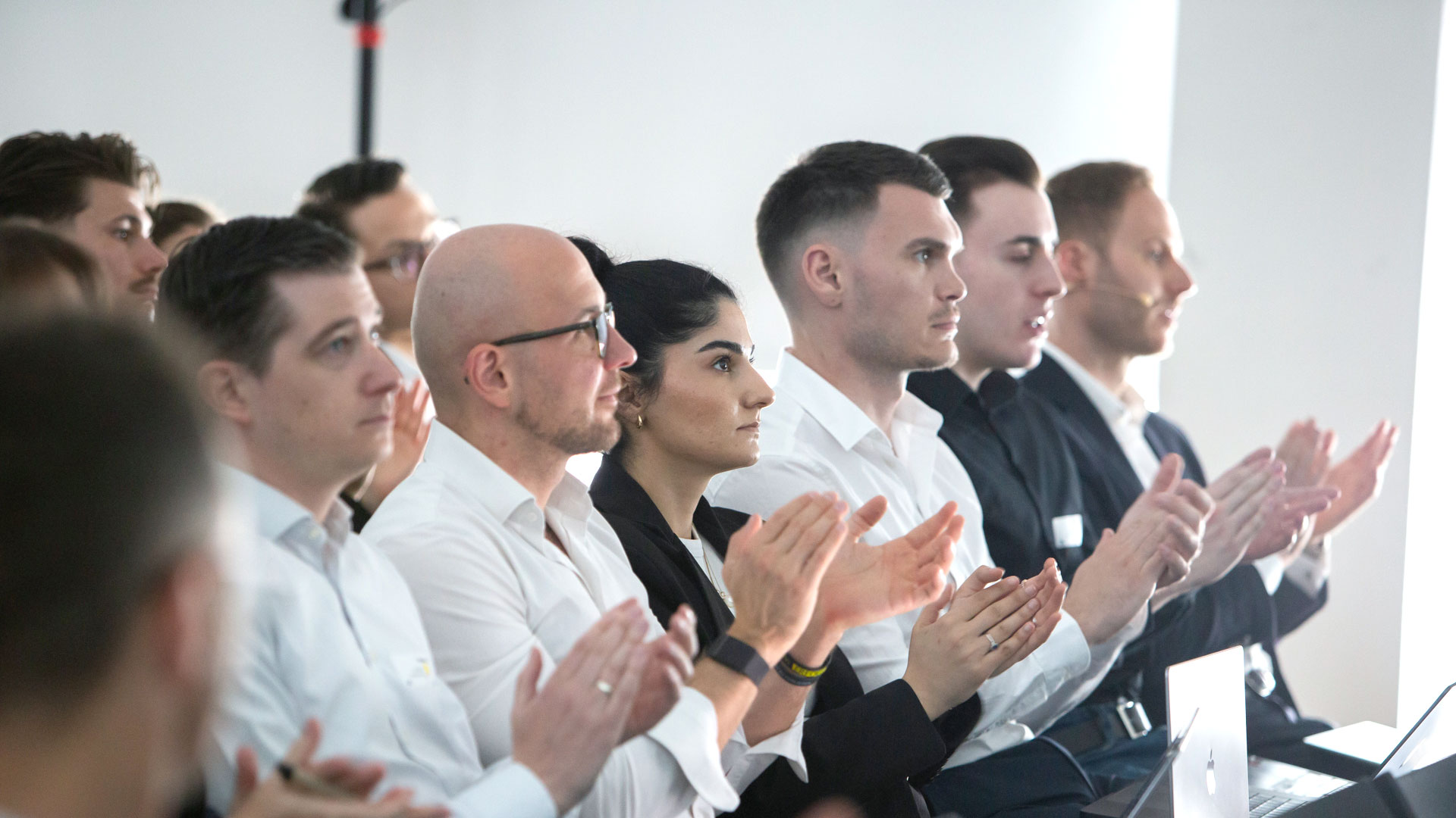 Applaudierende Teilnehmer sitzend im Plenum.