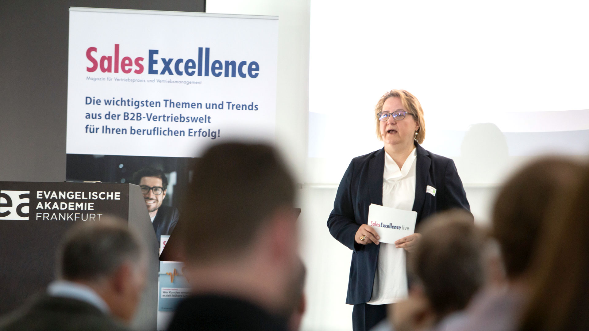 Eröffnung der Zukunftswerkstatt: Chefredakteurin Sales Excellence auf der Bühne vor Publikum. 