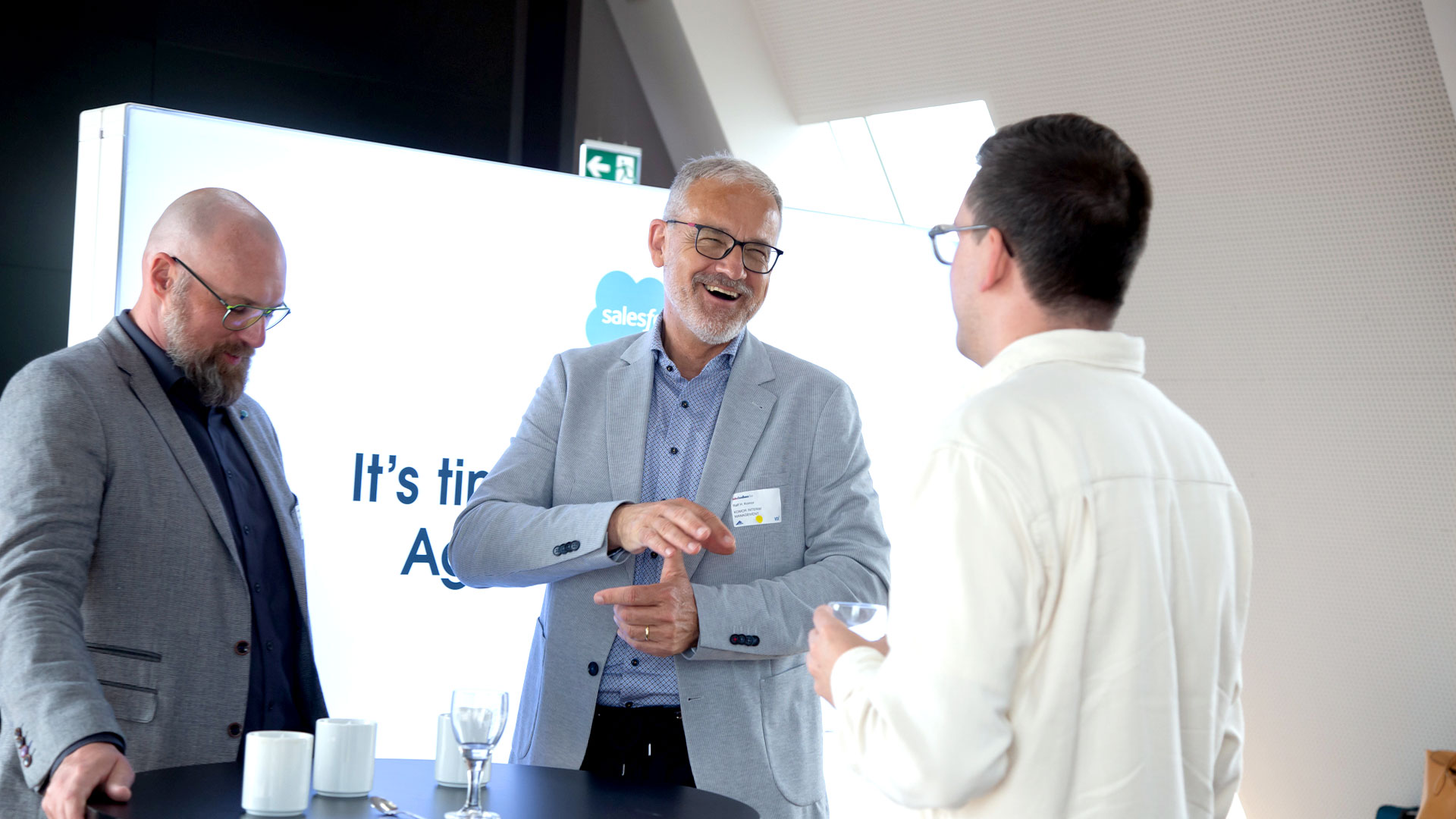 Drei Konferenzteilnehmer im Gespräch im Ausstellungsbereich