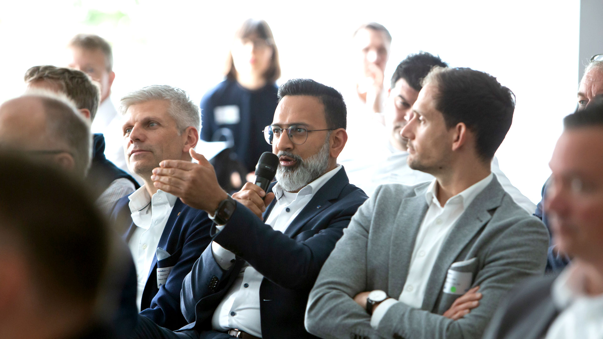Fragestellender Konferenzteilnehmer im Veranstaltungsraum