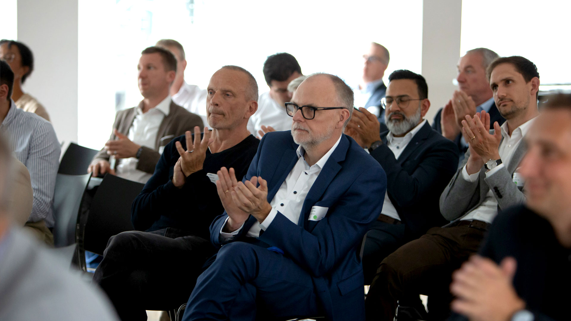 Klatschende Konferenzteilnehmer sitzend im Veranstaltungsraum
